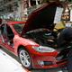Tesla staff work on a Model S vehicle at the company production facility in Fremont, California in 2015.